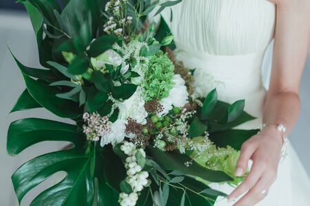 Wedding bridal bouquet with big tropical green leaves and white flowers.の写真素材