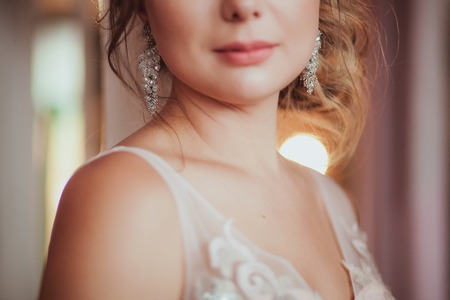 romantic Woman in bridal dress with wedding bouquet standing against the light. close-up. Indoor, interior, studio.の写真素材