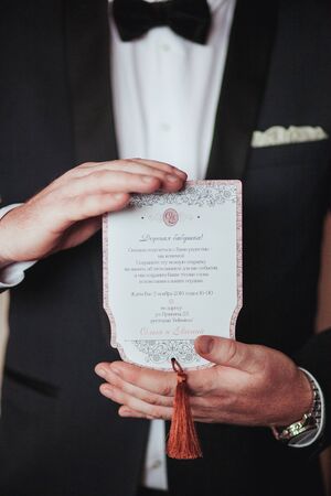 Wedding card in the hands of the groom.