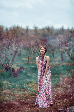 Young beautiful woman in a pink dress in the misty forest. Fairy tale, fantasy, legendの写真素材