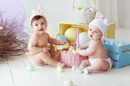 happy easter. happy funny baby girls playing with Easter eggsの写真素材