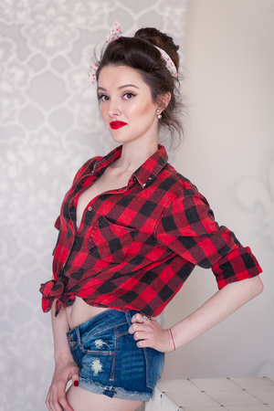 beautiful young woman on white background in old fashion clothes representing pinup and retro styleの写真素材