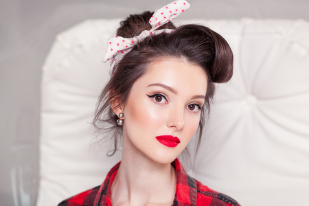 beautiful young woman on white background in old fashion clothes representing pinup and retro styleの写真素材