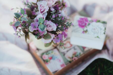 Beautiful artificial flower on white tablecloth with grass on backgroundの写真素材
