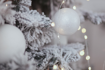 Vintage Christmas background with Christmas decoration on tree. White ball in focus and lights bokehの写真素材
