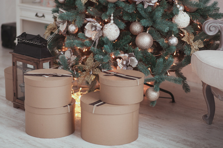 Hand crafted brown paper gifts on rustic wooden floor under Christmas tree.の写真素材