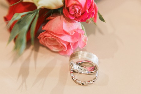 wedding rings on the floor next to the bouquetの写真素材