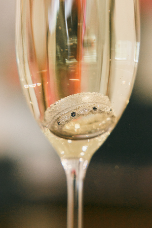 An engagement rings set inside a glass of champagne to ask the big question.の写真素材