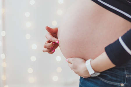 Pregnant women finger touch pointing on her bellyの写真素材