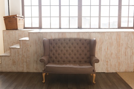 Classic brown fabric sofa and cozy lounge space with wooden backgrond and windowの写真素材