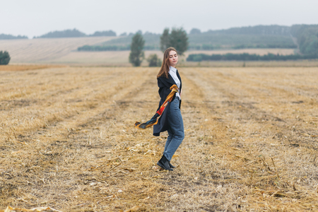 Beautiful smiling woman in a field at sunset. Autumn fall seasonの写真素材