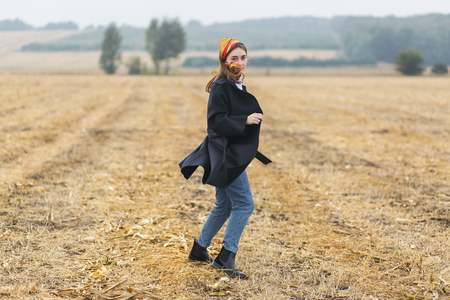 Beautiful smiling woman in a field at sunset. Autumn fall seasonの写真素材