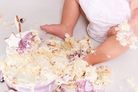 First birthday smash the cake. cream on legs. Close-up viewの写真素材