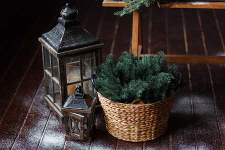Christmas background. Composition of a lantern and fir branches on floor, decorated with snowの写真素材