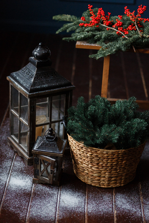 Christmas background. Composition of a lantern and fir branches on floor, decorated with snowの写真素材