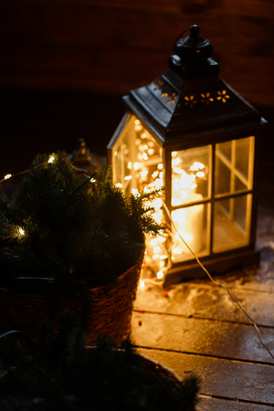 Lantern with led light garland inside. In dark room. Beautiful evening lights.の写真素材