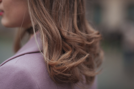 Stylish hairstyle concept. Light brown hair. Close up outdoor shot without faceの写真素材