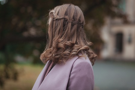 Woman with flying hair from back in the street.の写真素材