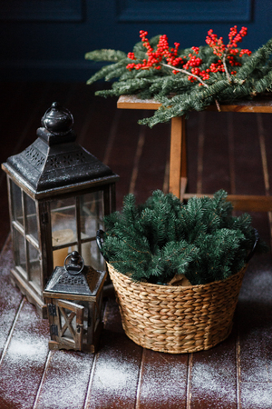 Christmas background. Composition of a lantern and fir branches on floor, decorated with snowの写真素材