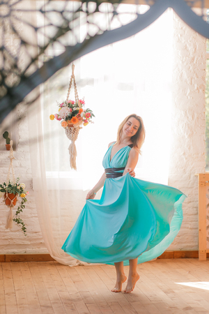 Happy woman in dress dancing bare foot in vintage roomの写真素材