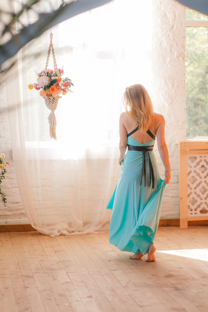 Girl dances in a big hall in front of windowsの写真素材