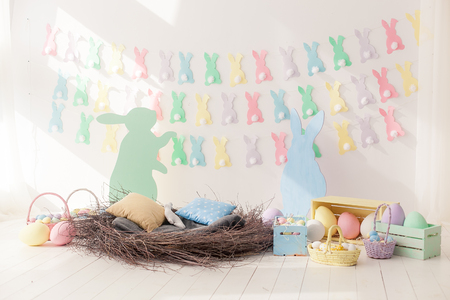 Colorful Easter Eggs in Nest from and baskets with space for copy text on wall backgroundの写真素材