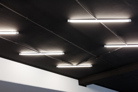 Led tube lights on black office ceiling. Minimal loft designの写真素材