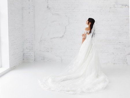 Bride stands at the high brick wallの写真素材