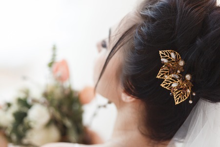 Rear view of young beautiful bride with a hair clip in hair. Professional make-up and hair-style.の写真素材