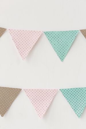 Design vintage fabric party flag over white wall texture background, close-up vertical photoの写真素材
