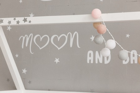 Baby bedroom decoration close-up shot. Mum text on gray wallの写真素材