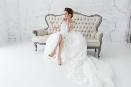 Happy bride smile and talking with her friend in smartphone looking to her nailsの写真素材