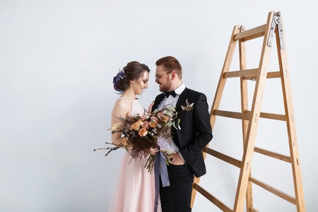 Happy bride and groom on ladder at studioの写真素材
