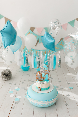 Incredibly beautiful cream cake in mint and white, timed to the first birthday, decorated with a paper garland, gingerbreadの写真素材