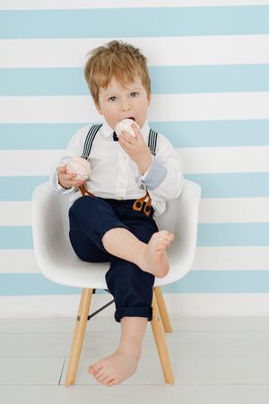 Little Boy Sitting on Chair Eating Marshmallowの写真素材