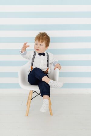 Cute Little Boy Sitting on Chair Displeased Childの写真素材