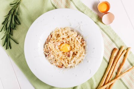 Carbonara Pasta with Ham Egg Yolk and Cheese Topの写真素材