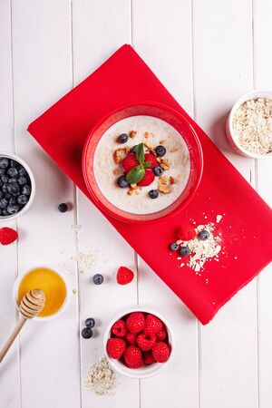 Oatmeal Berry Breakfast in Red Bowl Top Flat Layの写真素材