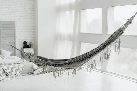 White Big Cozy Bedroom Interior with Grey Hammockの写真素材