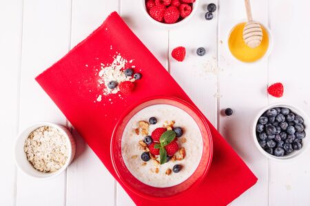 Oat Cereal Breakfast in Red Bowl with Rasperryの写真素材