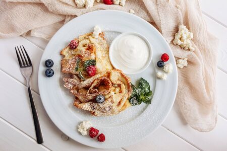 closeup of pancakes with cottage cheeseand strawberry, blueberry on plate on white plate background, decorated with mint leavesの写真素材