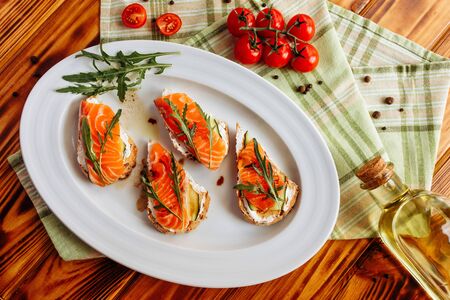 Whole grain bread with avocado paste and salmon decorated with arugula. Top viewの写真素材