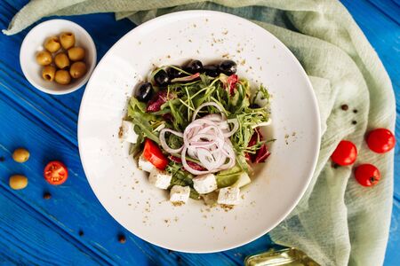 Salad with arugula, tomato, cheese, olives and red onion. Whole plate top horizontal viewの写真素材