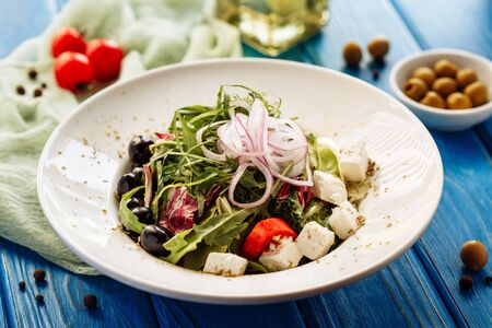 Salad with arugula, tomato, cheese and red onion. Whole plate viewの写真素材
