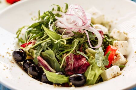 Salad with arugula, tomato, cheese and red onion. Close view for restaurant menuの写真素材