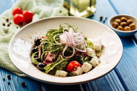 Salad with arugula, tomato, cheese and red onion. Whole plate viewの写真素材