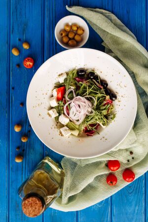 Salad with arugula, tomato, cheese, olives and red onion. Whole plate top horizontal viewの写真素材