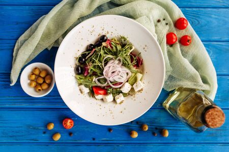 Salad with arugula, tomato, cheese, olives and red onion. Whole plate top horizontal viewの写真素材