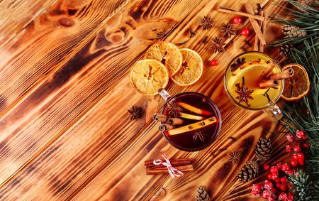 One glass cup of christmas mulled wine or gluhwein with spices and orange slices on rustic wooden table top view. Traditional drink on winter holiday. Vintage tonedの写真素材