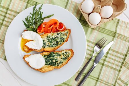 Whole wheat toasted bread with arugula and poached egg, smoked salmon. Table arrengement top view copy spaceの写真素材